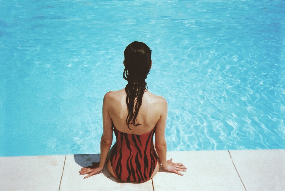 Jeune femme au bord d'une piscine pendant sa séance de natation