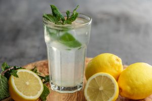 Verre détox d'eau glacée et de jus de citron avec feuilles de menthe fraiche