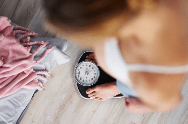 Femme qui se pèse sur une balance