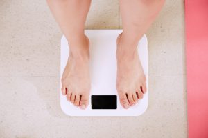 Vue sur les pieds d'une personne en train de se peser sur une balance