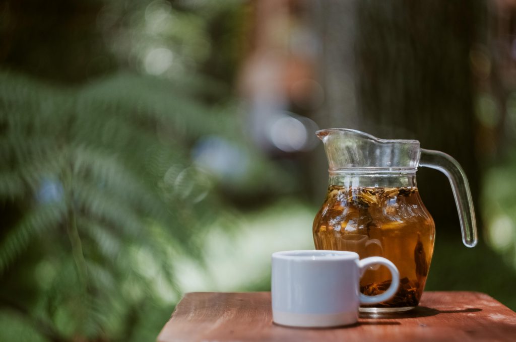 Pot d'infusion à la camomille avec tasse blanche sur une table en bois