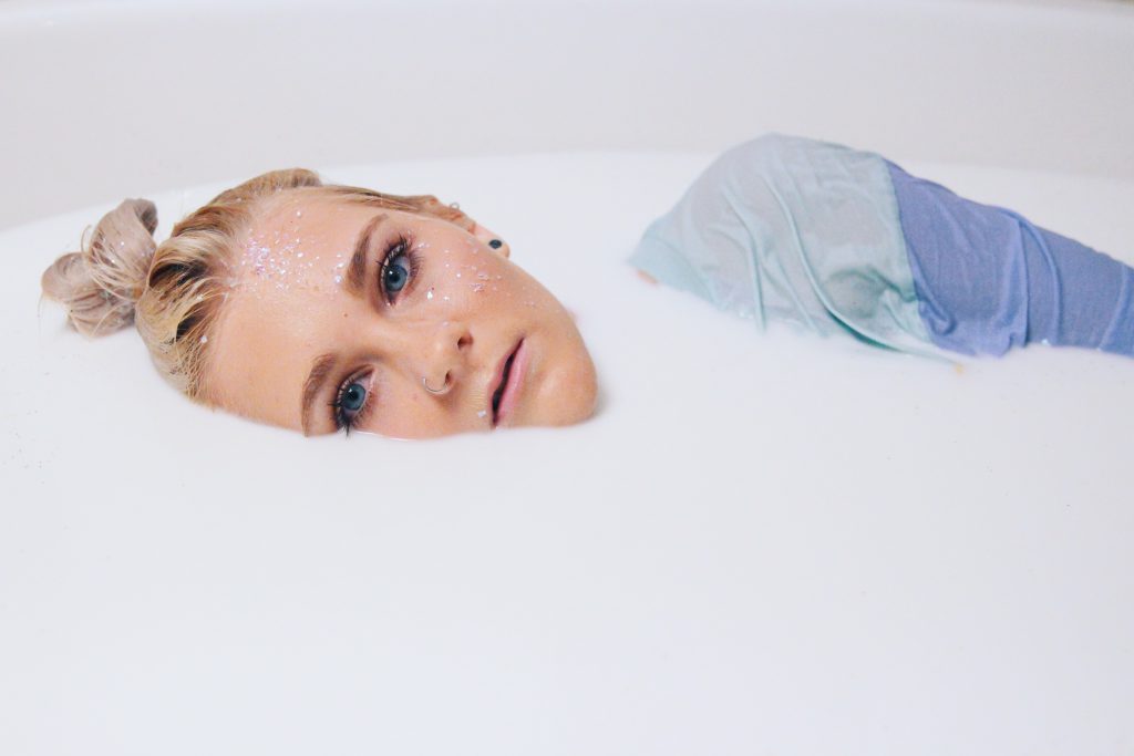 Photo artistique d'une jeune femme couchée dans un bain de lait