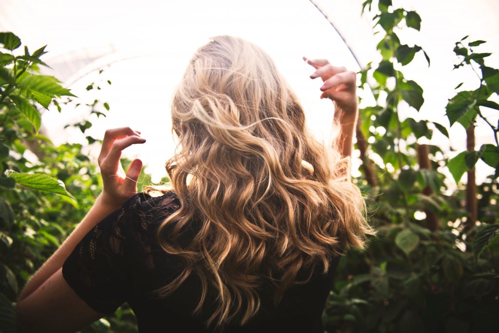 Femme de dos avec les cheveux blonds bouclés