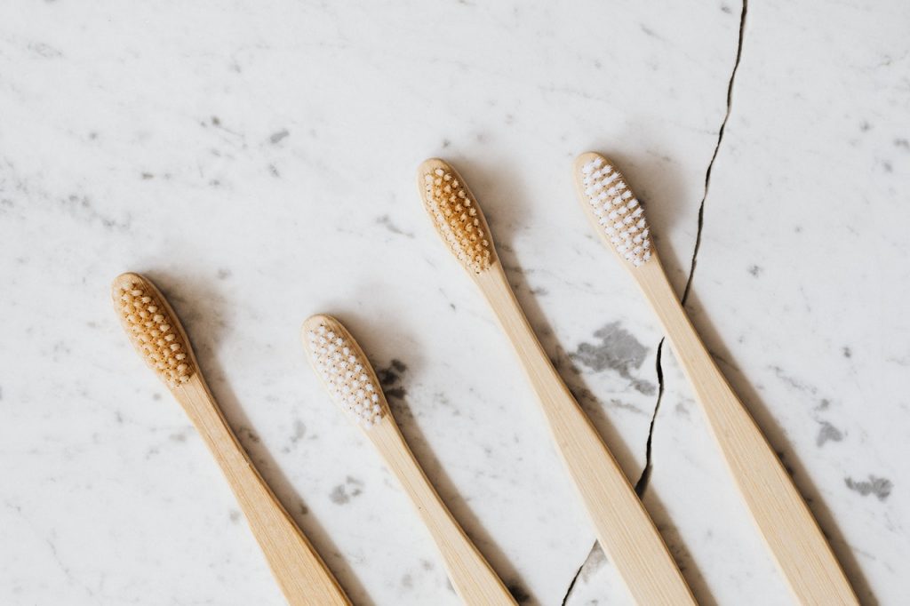 4 brosses avec un manche en bois posés sur du marbre