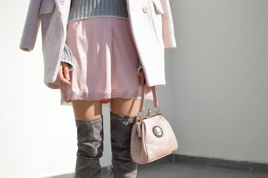 tenue d'automne composée d'un manteau, d'une jupe et d'un sac à main rose