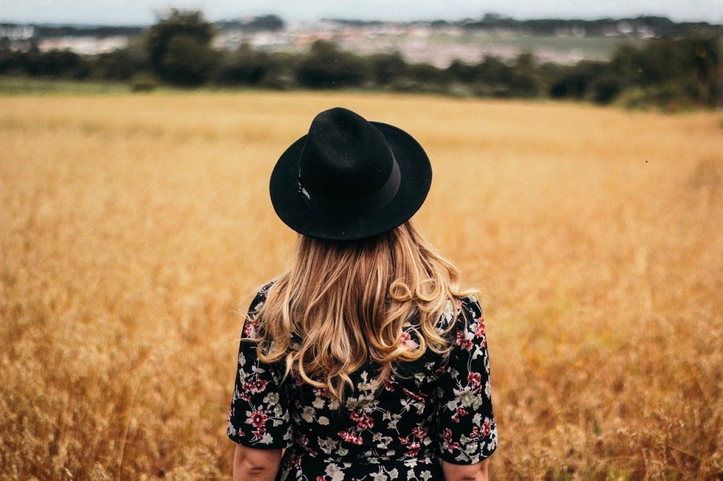 jeune femme de dos au milieu d'un champ de blé