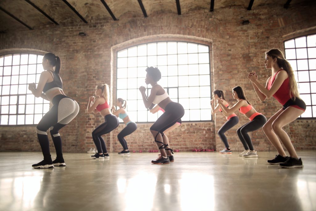 Exercice de squats pendant un cours d'abdos-fessiers