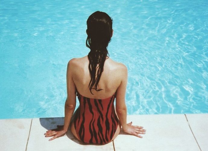Femme assise au bord d'une piscine