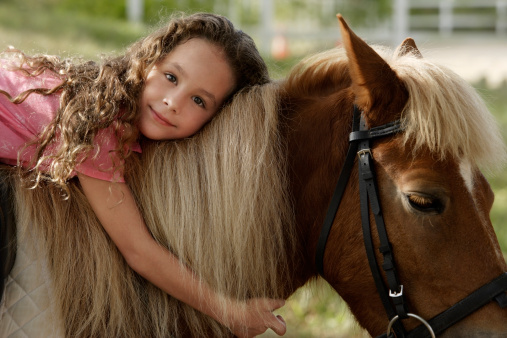 Petit fille assise sur un poney