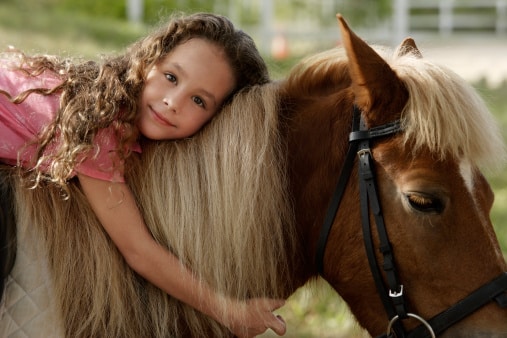 Petit fille assise sur un poney