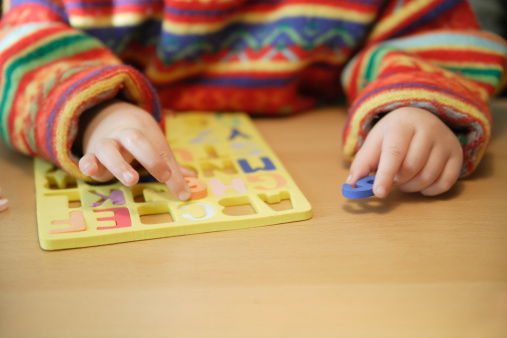 Enfant plaçant des chiffres et des lettres dans des cases