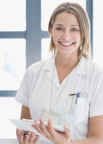 Infirmière souriant et portant des documents