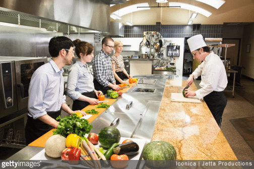 Un chef cuisinier et des apprentis dans une cuisine de restaurant