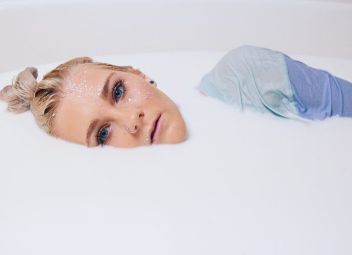 Photo artistique d'une jeune femme couchée dans un bain de lait